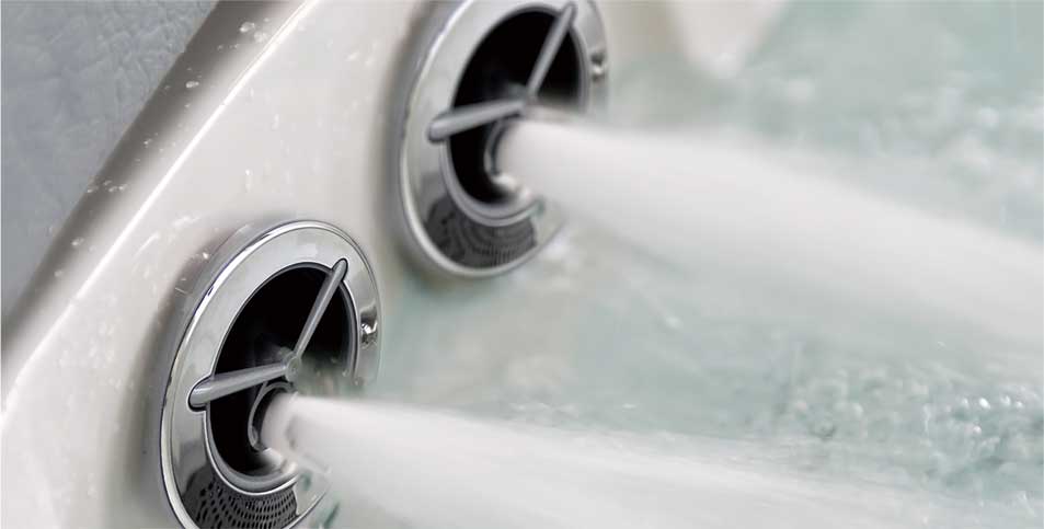 Hot tub jets with water flowing out, close-up view.
